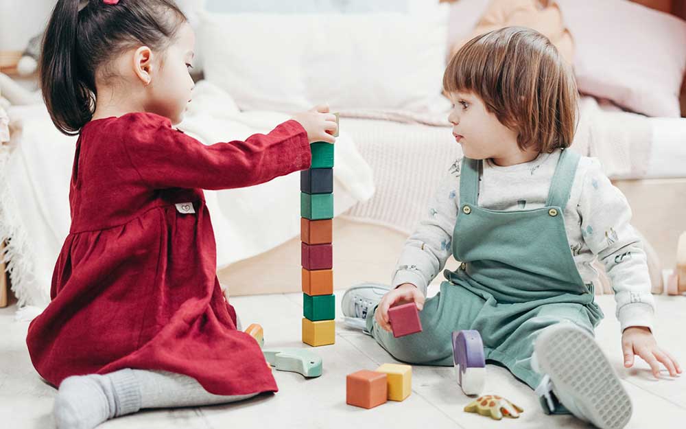 Zwei Kinder spielen mit Bauklötzen