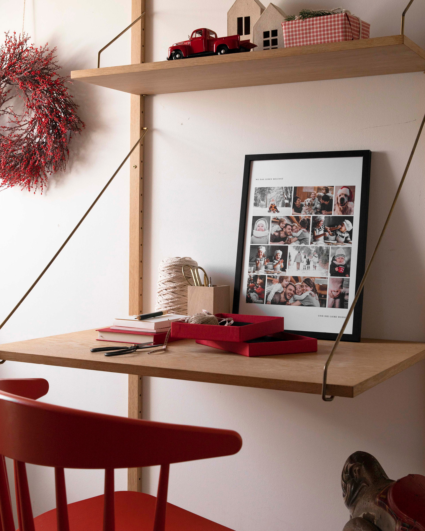 Poster mit vielen Familienfoto steht auf einem Schreibtisch und lehnt an der Wand.