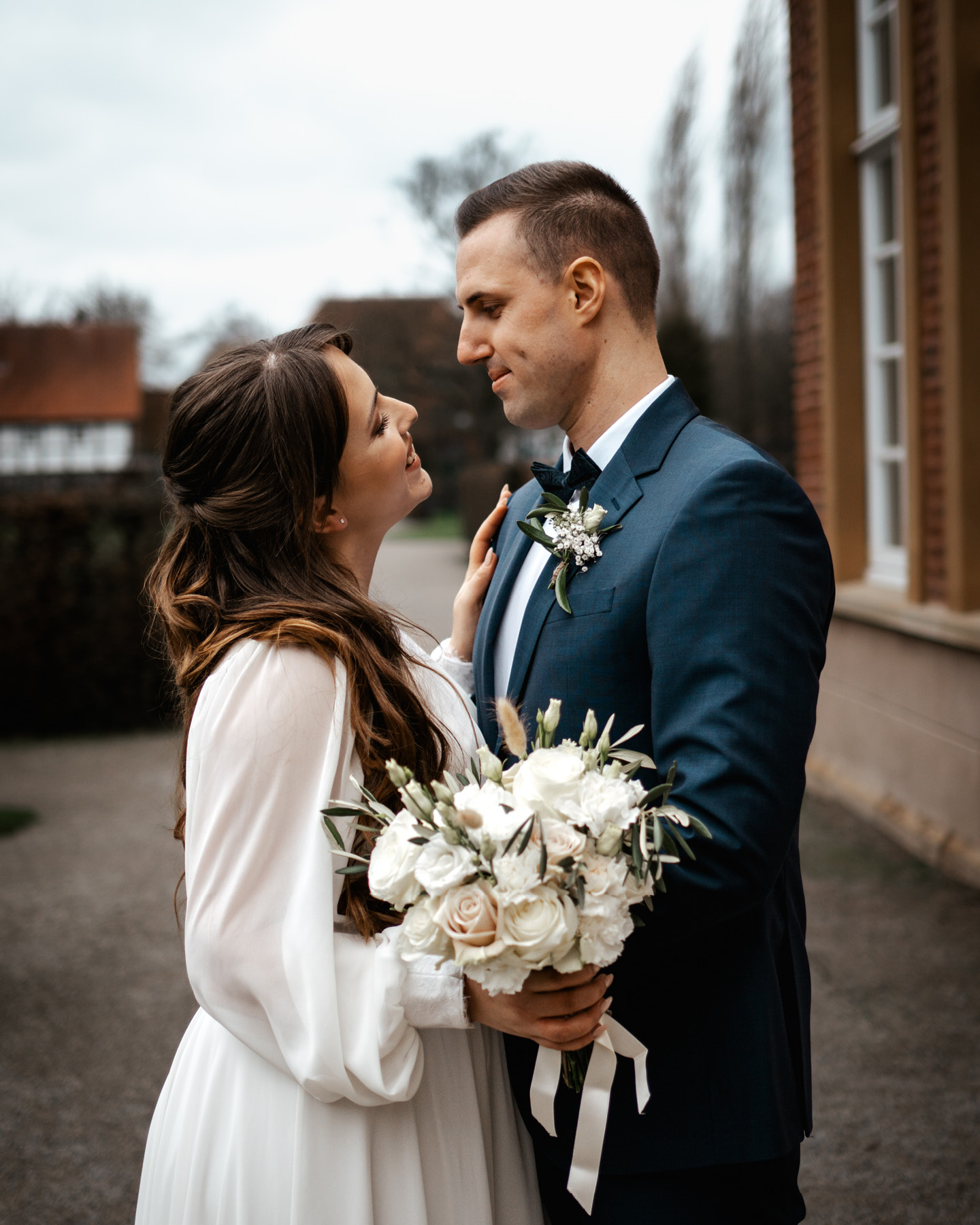 Hochzeitspaar schaut sich in die Augen, während sie den Brautstrauß halten.