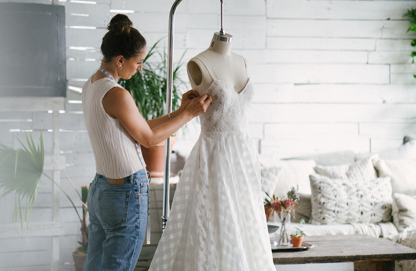 Schneiderin ändert Brautkleid an Schneiderbüste ab.