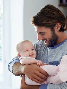 Vater hält kleine Tochter im Arm