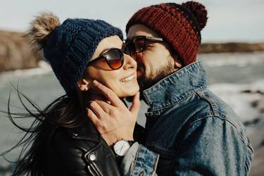 Mann und Frau in zärtlicher Pose im Winter an einem Fluss