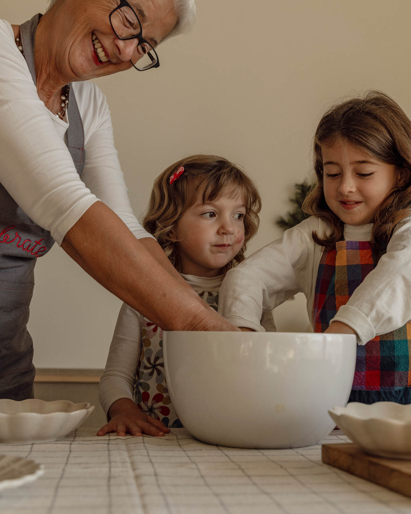 Oma und ihre zwei Enkelinnen bereiten Teig für Weihnachtsplätzchen vor