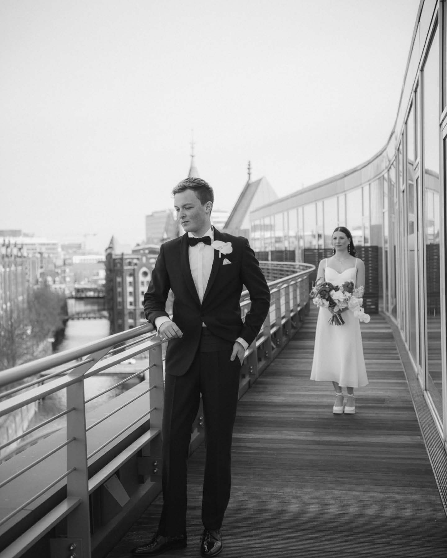 Das Hochzeitspaar steht auf einer Terrasse mit Aussicht.