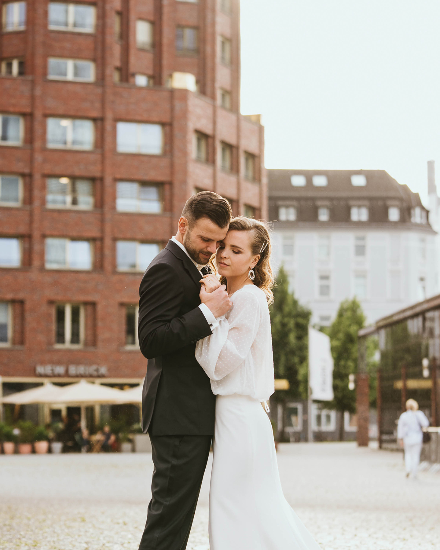 Hochzeitspaar steht auf dem Marktplatz.