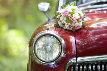 hochzeitlich geschmückter roter Oldtimer