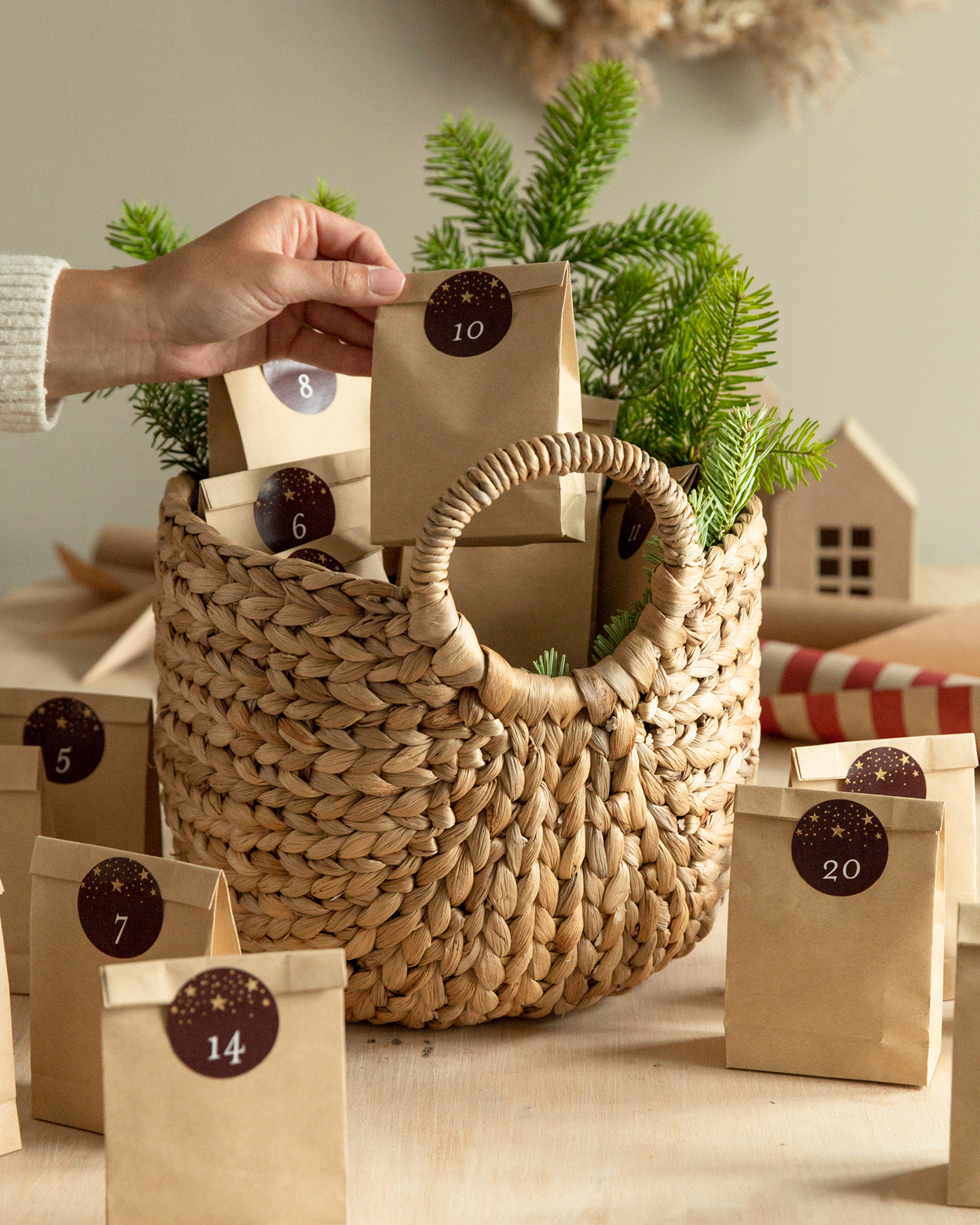 Adventskalender aus Kraftpapiertüten wird befüllt und dekoriert.